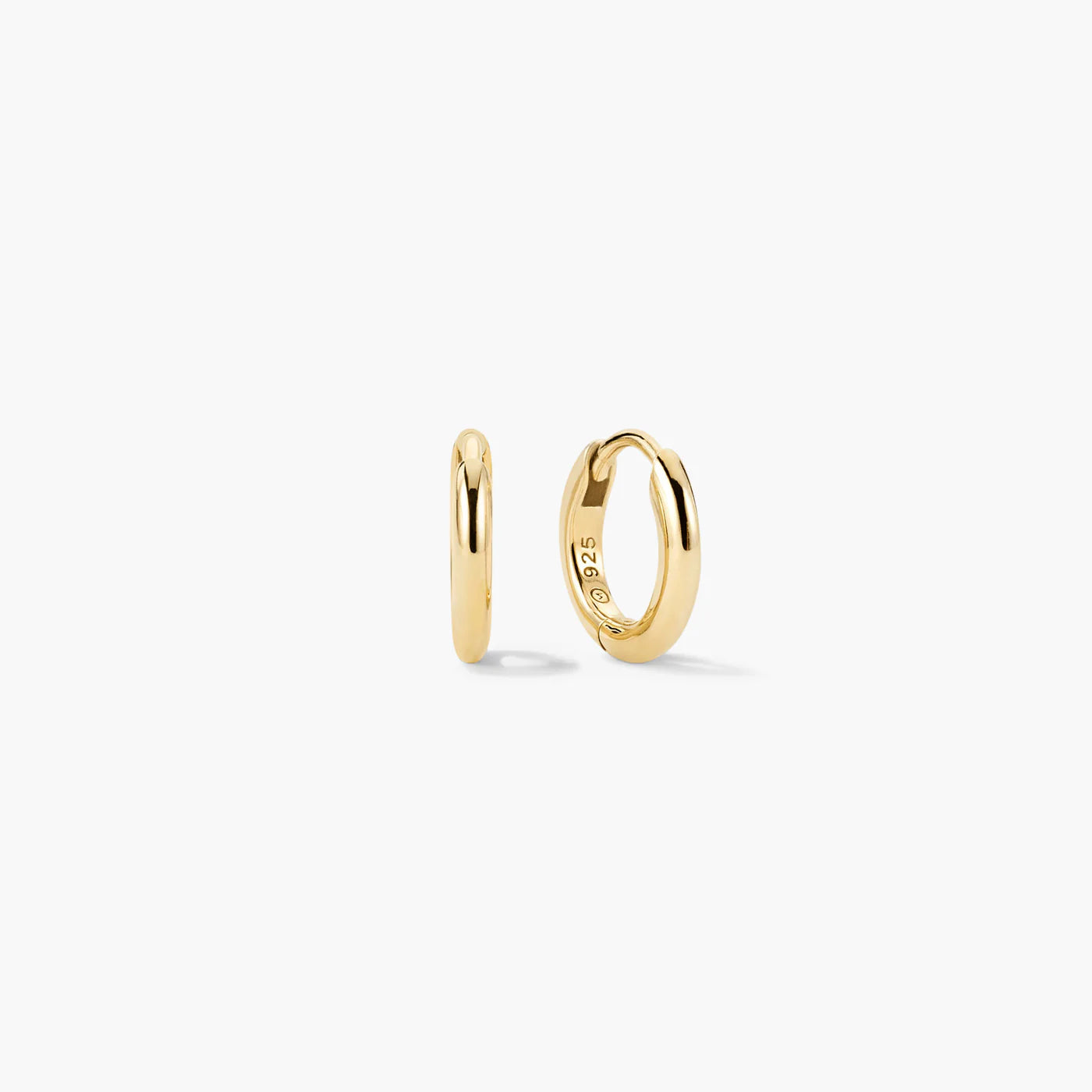 Gold-tone tube huggie hoop earrings, angled view