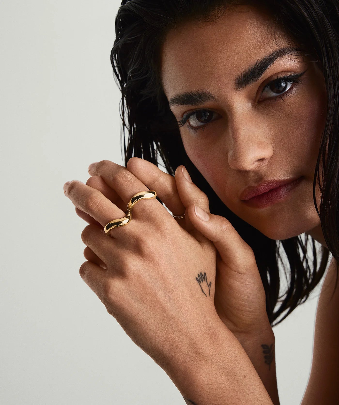 Gold Dôme Figure Ring stacked with slimmer bands