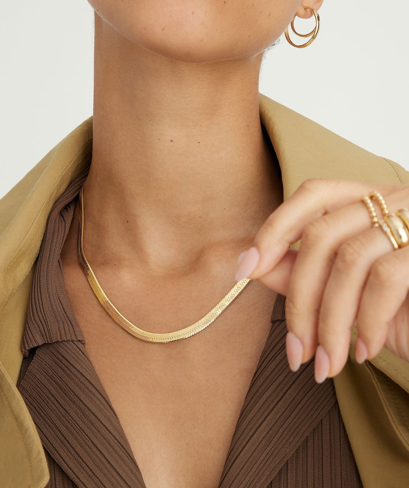 Herringbone chain necklace worn layered on a neckline
