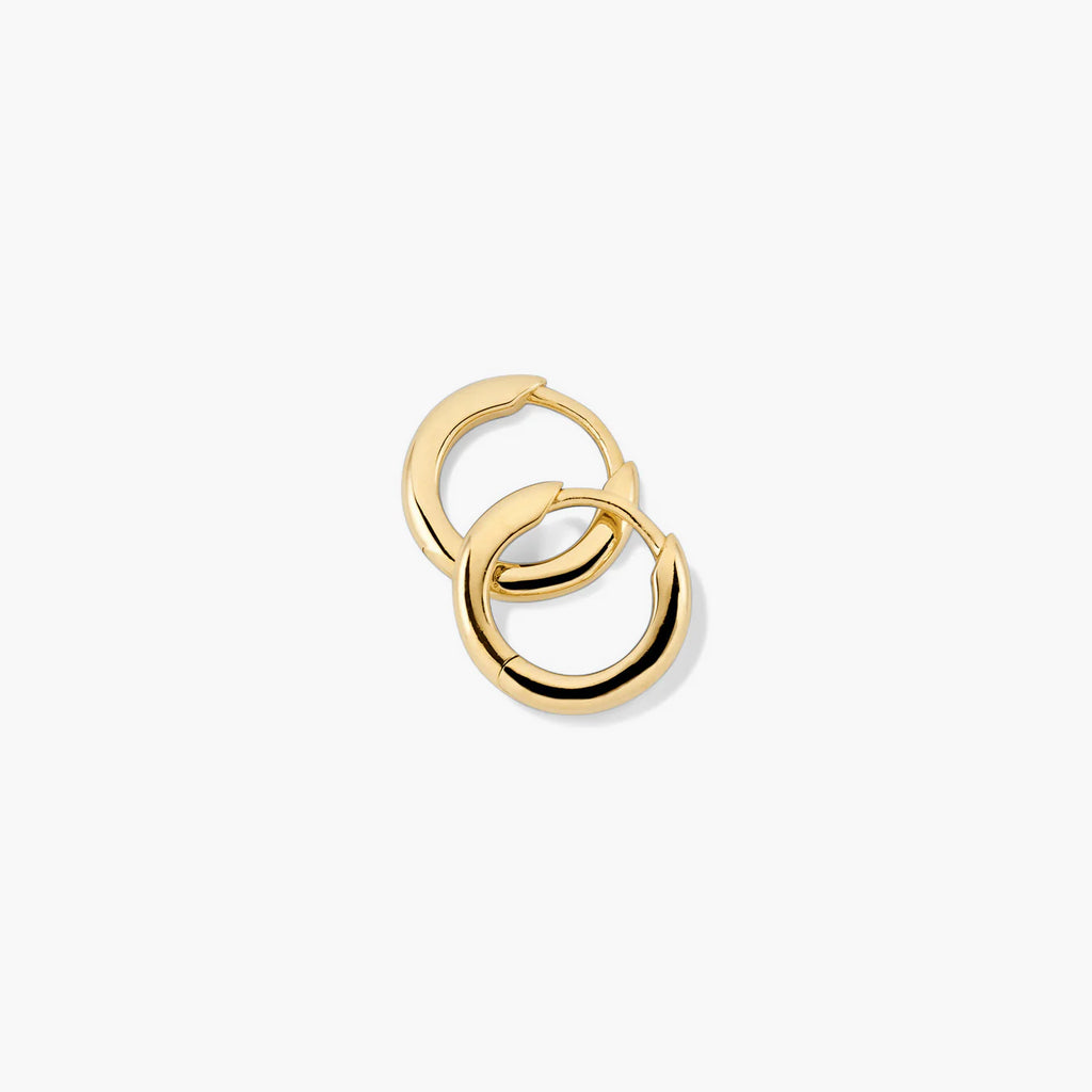 Pair of gold-tone tube huggie hoops laid flat
