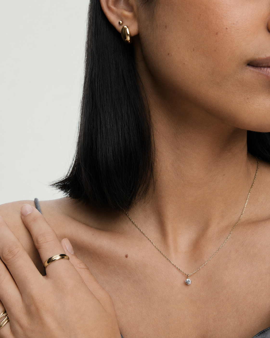 Round solitaire pendant necklace worn at the collarbone